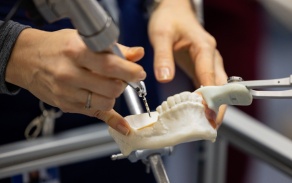 Close up of a surgical robot testing the depth for implant surgery.